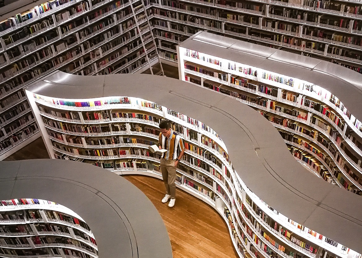 white wavy library shelves with books