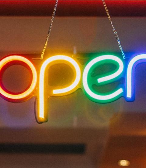 Colourful neon sign spelling: open